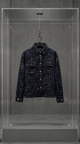 Camisa overshirt AMIRI de tweed preto com fios brancos, vista frontal, em vitrine de acrílico