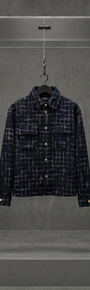 Camisa overshirt AMIRI de tweed preto com fios brancos, vista frontal, em vitrine de acrílico