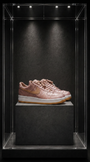 Tênis Nike Air Force 1 x CLOT Rose Gold Silk, em seda rosé com estampa jacquard, sobre pedestal em vitrine