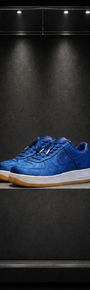 Tênis Nike Air Force 1 x CLOT Royale University Blue Silk, em seda azul com jacquard, sobre pedestal em vitrine