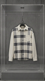 Camisa overshirt Palm Angels de flanela xadrez creme e preta, vista frontal, em vitrine de acrílico