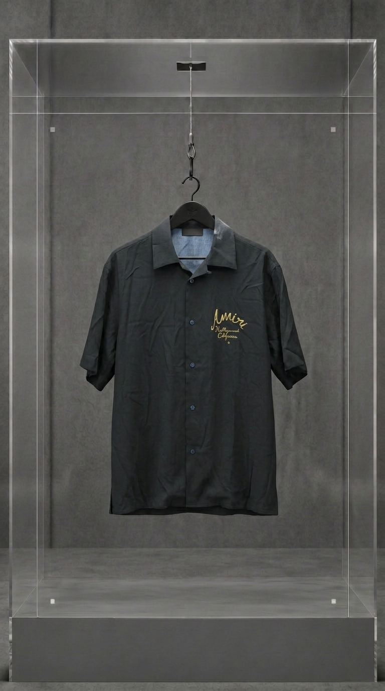 Camisa AMIRI preta de manga curta com assinatura Hollywood California bordada em dourado, em vitrine