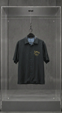 Camisa AMIRI preta de manga curta com assinatura Hollywood California bordada em dourado, em vitrine