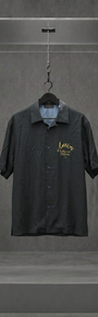 Camisa AMIRI preta de manga curta com assinatura Hollywood California bordada em dourado, em vitrine