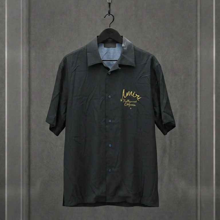 Camisa AMIRI preta de manga curta com assinatura Hollywood California bordada em dourado, em vitrine
