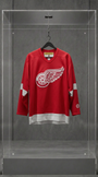 Jersey vintage Detroit Red Wings vermelha de manga longa com o logo da roda alada, em vitrine de acrílico